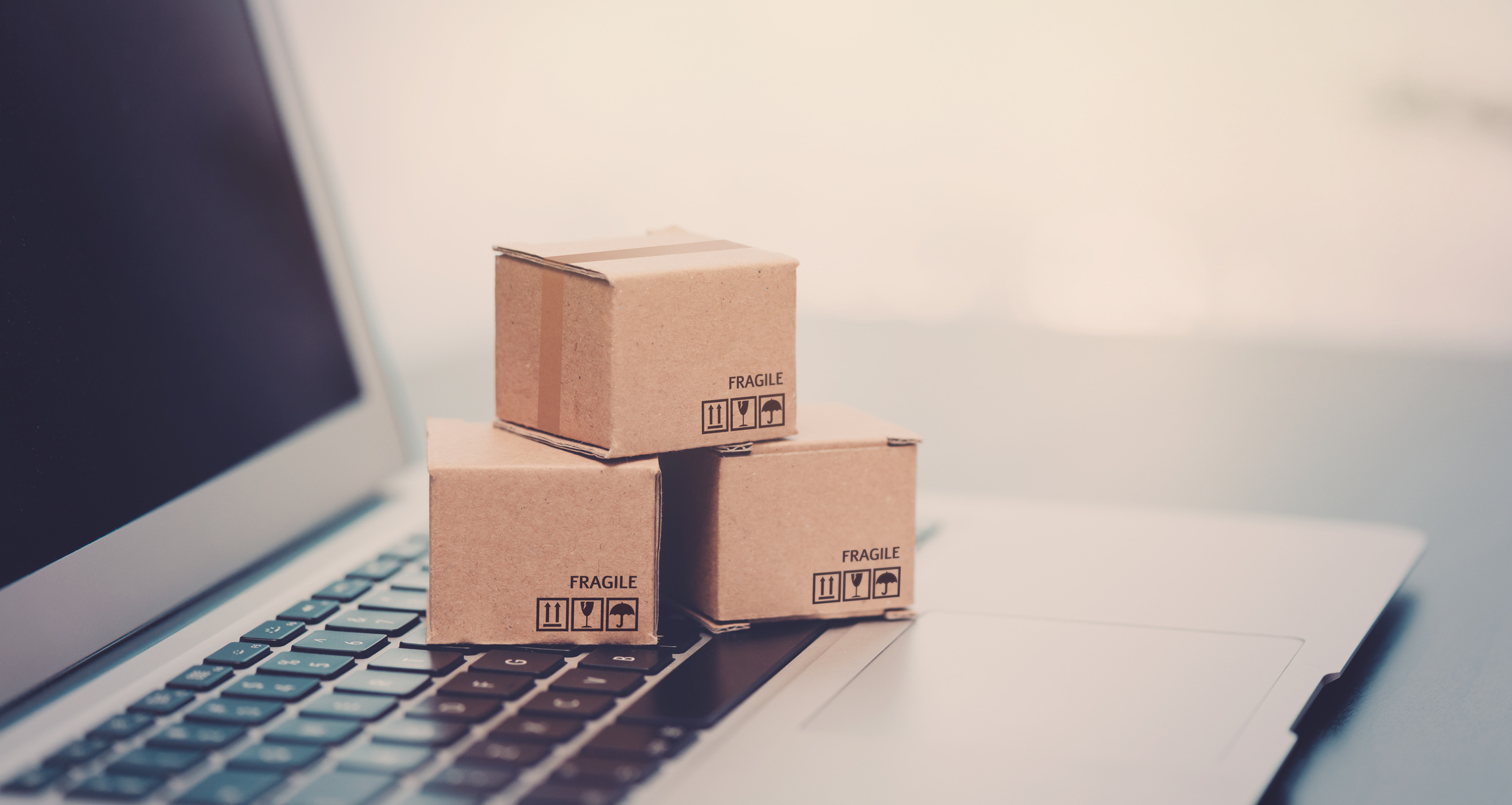 Boxes on laptop keyboard. E-commerce, shopping